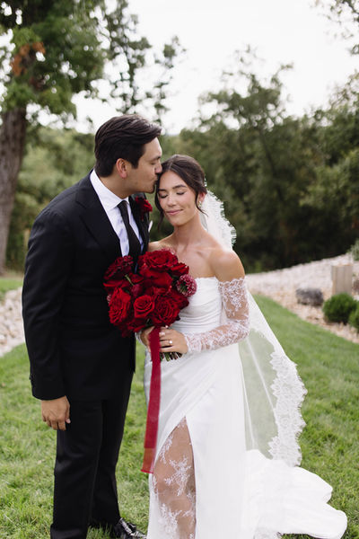 Bride and groom portrait with all red rose bouquet