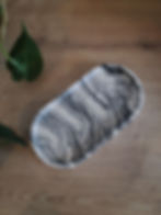 Plateau décoratif ovale, fabriqué en Jesmonite, coloris marbré noir et blanc.