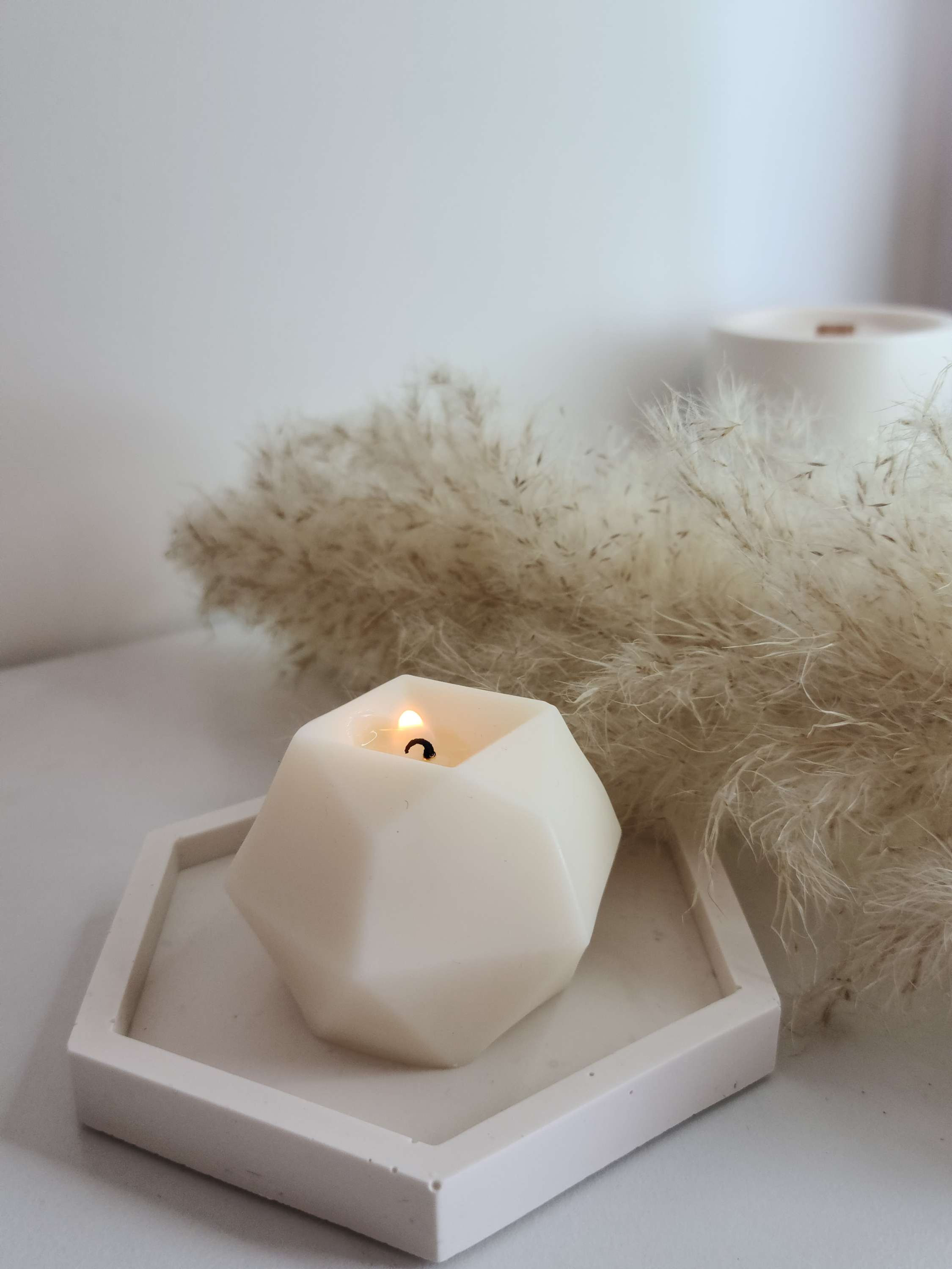 Petite bougie décorative et parfumée, en cire d'olive, plusieurs parfums disponibles. Sur un vide-poche hexagonal fabrique en Jesmonite.