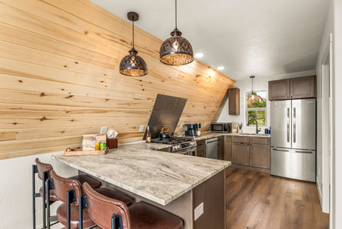 Custom A-Frame kitchen in Colorado with wood accents, modern appliances, and open layout designed by Rocky Mountain Developers.