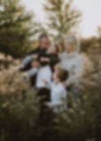 A family laughing in a field of flowers, taken by Toronto family photographer, Willow and Wild Photography.
