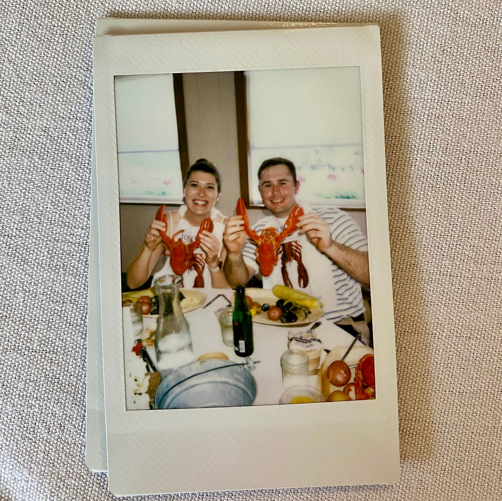 photo of us holding up cooked lobsters at our lobster dinner