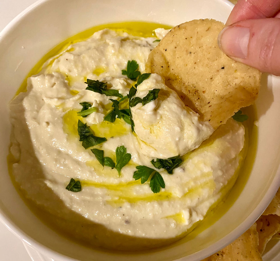 whipped feta and white bean dip being scooped with a chip