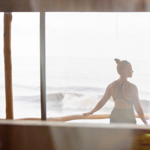 A woman watching the sea in a tree house balcony.