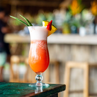 A red cocktail on a green table.