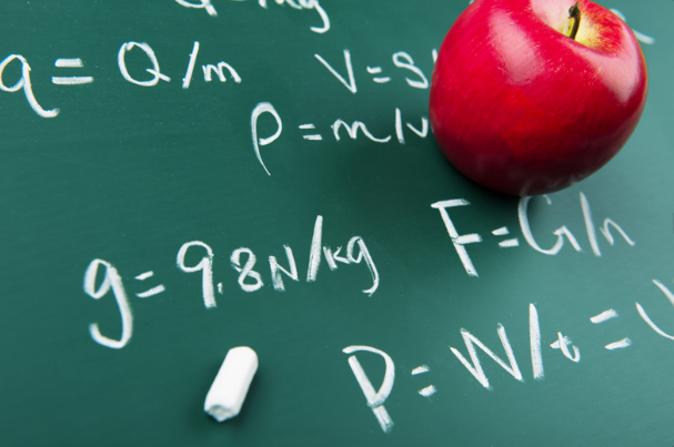 an apple on a blackboard having physics equation