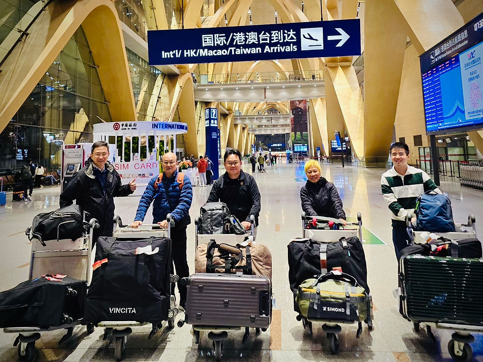 A group of tour participants in an Airport in Kun Ming with rolls of trolleys with their carry on luggage, Brompton hard and soft cases