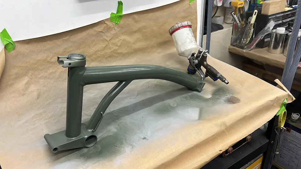 Brompton frame freshly sprayed sage green during a paint touch up at the workshop