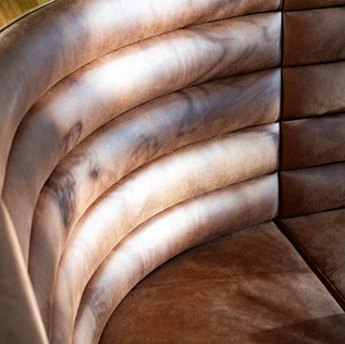 Curved brown leather booth seating