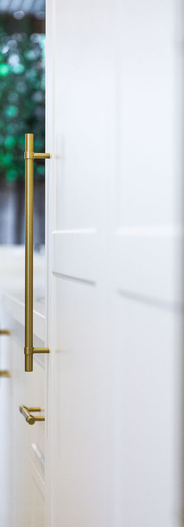 Gold bar pulls on white kitchen cabinets