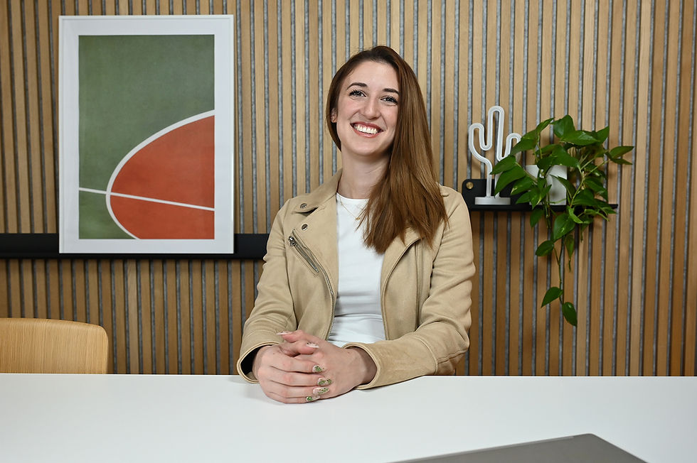 Amandine Borquin während eines Interviews, sitzend und konzentriert beim Beantworten von Fragen, mit sichtbarem Mikrofon vor neutralem Hintergrund.