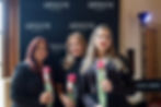 Three women holding roses at an Armani Beauty pop-up event