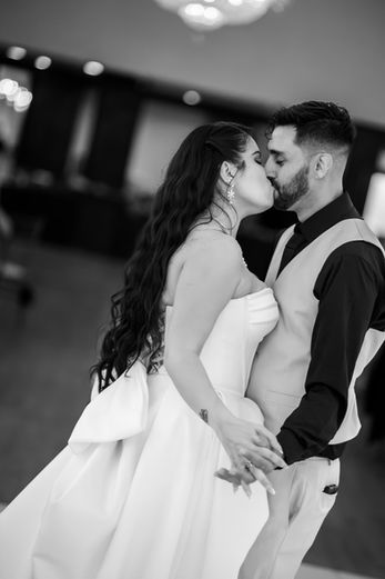 Black-and-white wedding reception photography capturing guests dancing and celebrating with the newlyweds.