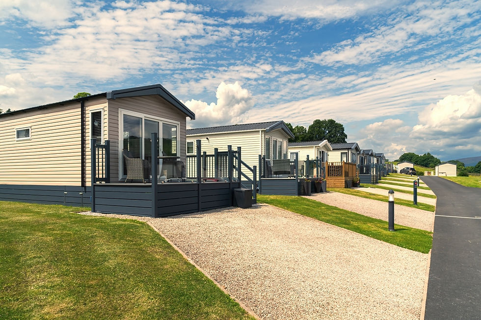 Static caravans in a row showing their driveways and decking.