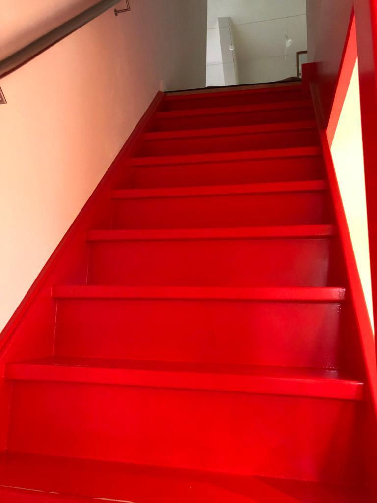 Trap gemoderniseerd door knalrode lak op een moderne trap. erg moderne look