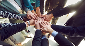 Close up top view photo of diverse business people putting their arms together. Stack of h
