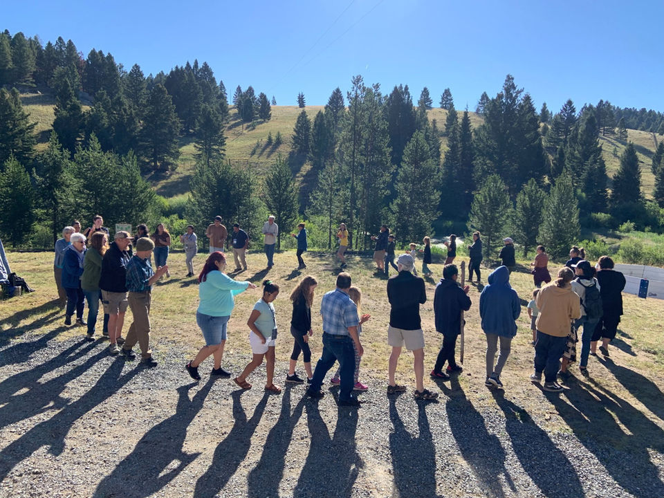 large group of people standing in a circle in a field