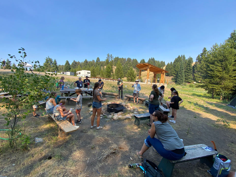 group of people of various ages around a fire pit