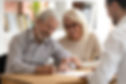 Happy older family couple clients make sale purchase deal sign insurance contract meeting