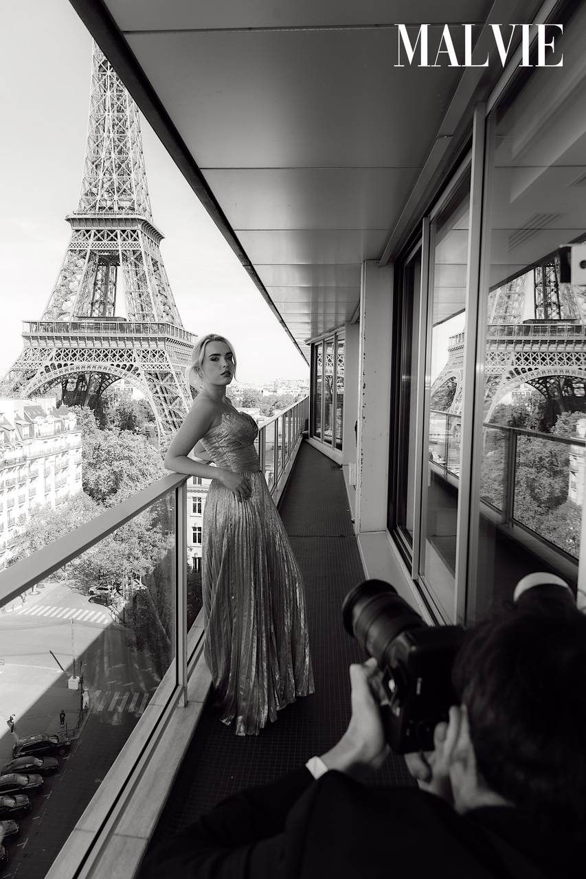 Black and white: Olivia Gear in her gown on a long balcony while photographers shoot her