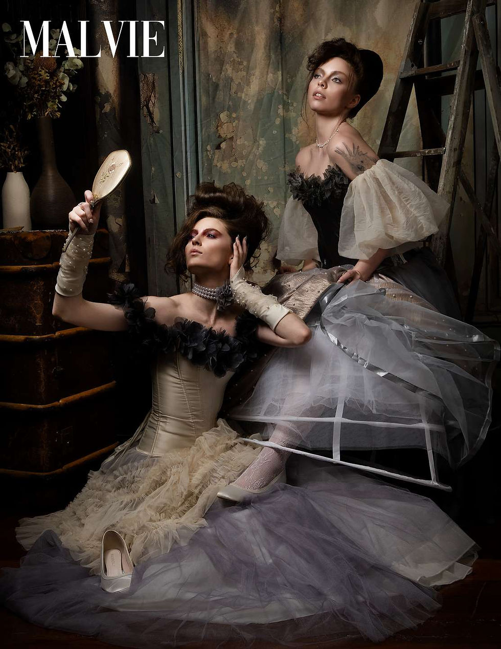 Lilly Potter and Marie in corseted ball gowns, one seated holding a hand mirror, the other perched behind her