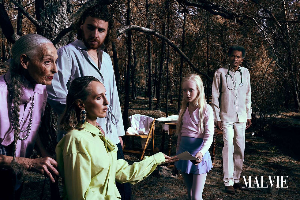 Group among burnt trees: an older woman, a woman in lime green, two men and a girl by a small table