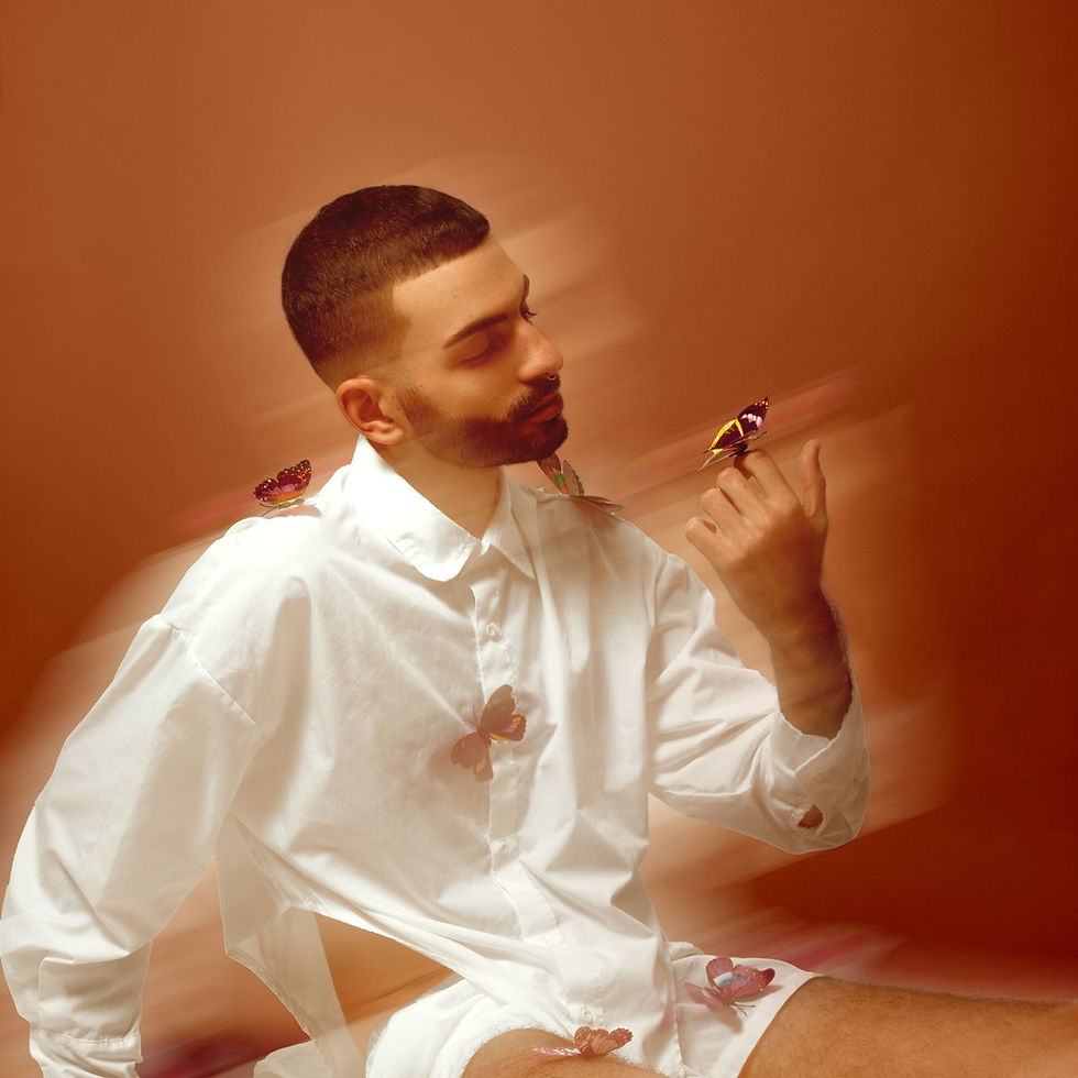 Jose Gallardo in a white shirt with a butterfly on his raised hand – Quietud by Juanfe Gómez for MALVIE Magazine
