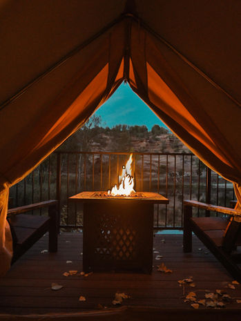 View of a fire pit looking out from inside a Cave Lakes glamping tent near Zion National Park.