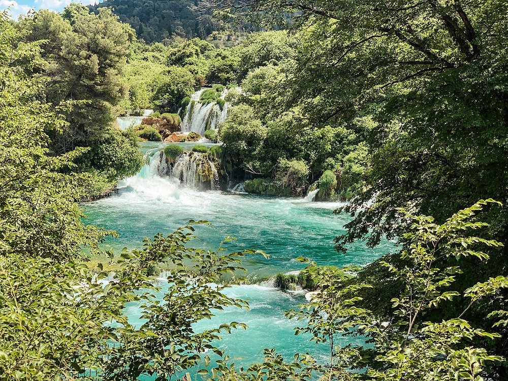 Krka's lush foliage and travertine waterfalls