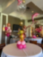 Thumbnail: A small balloon centerpiece. Colors: shades of pink and a seahorse shaped balloon on top
