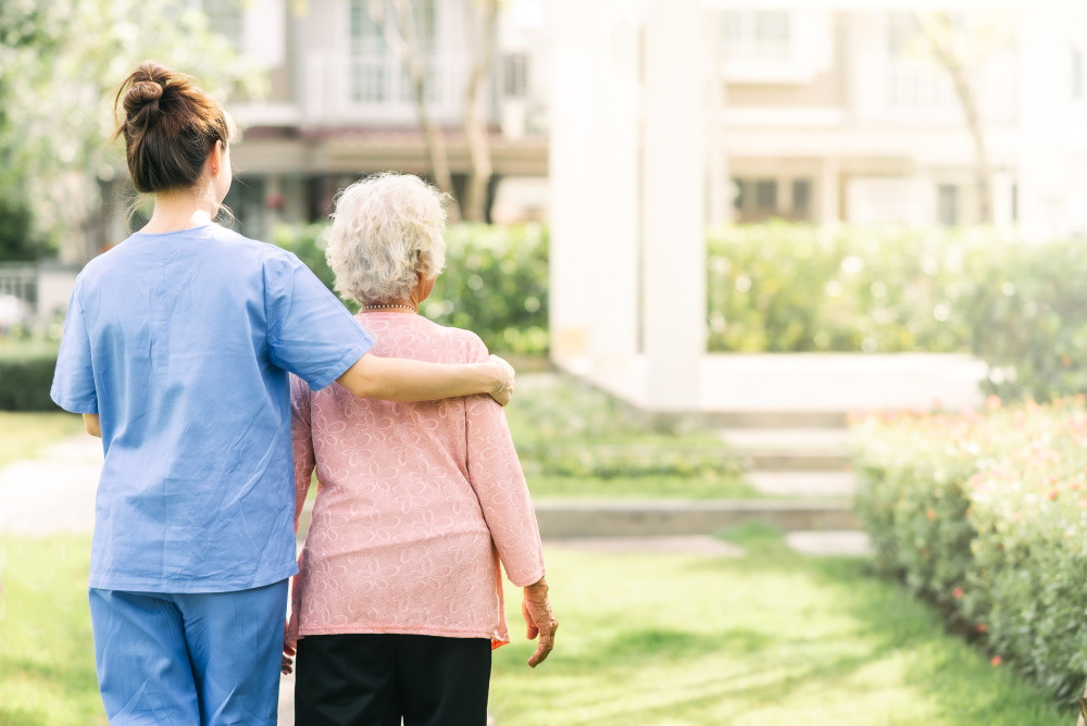 Assisted living resident walking with staff member
