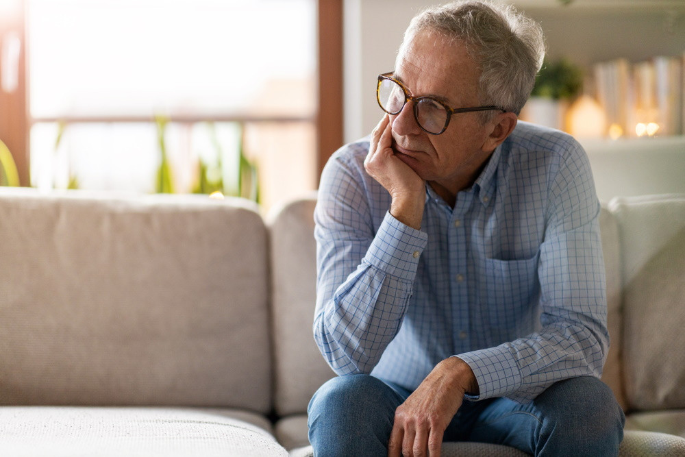 older man sitting on couch at home