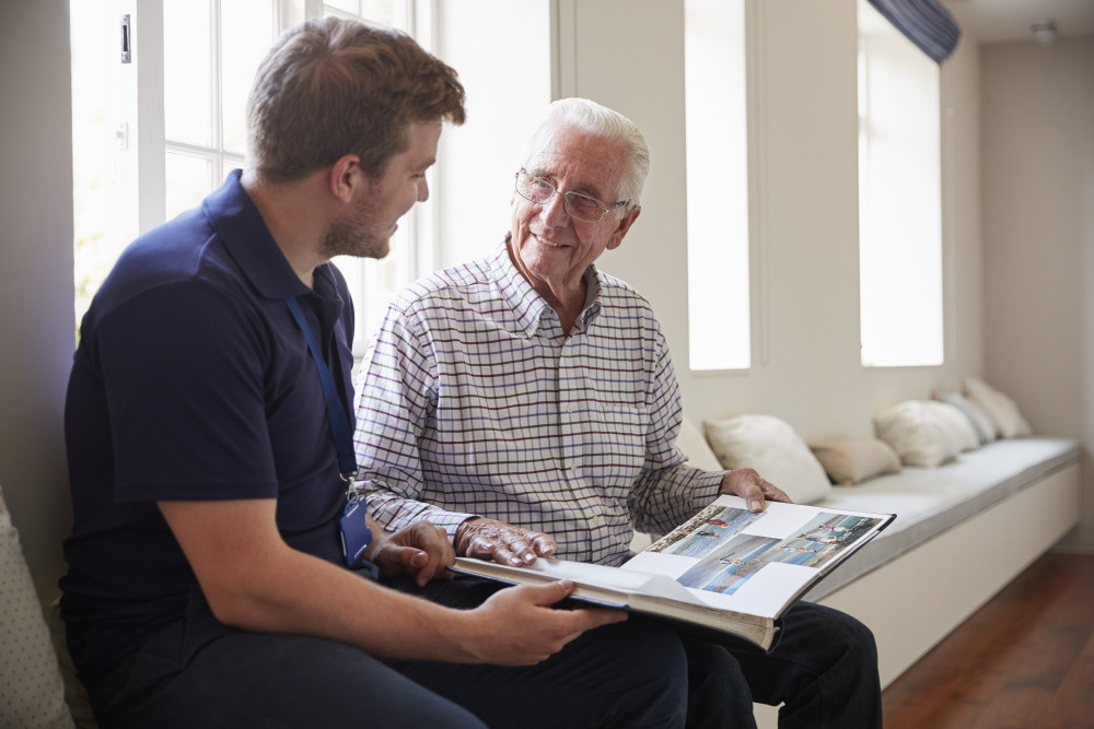 memory care facility resident and staff member looking at photo album