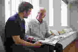 memory care facility resident and staff member looking at photo album
