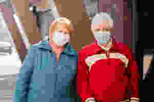 senior citizens wearing face masks outside a building