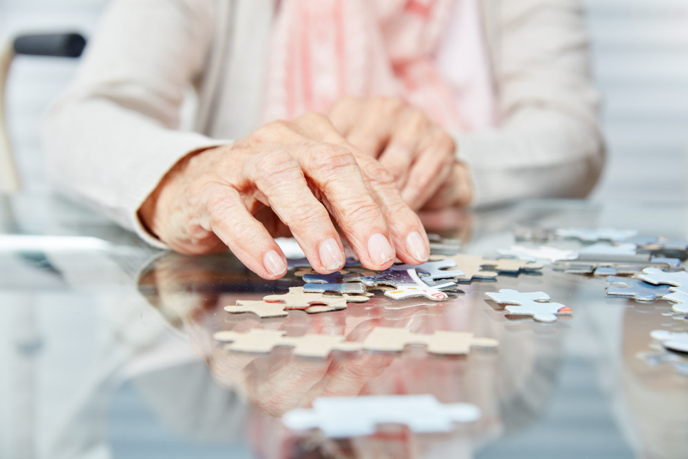 Elderly woman holding puzzle pieces