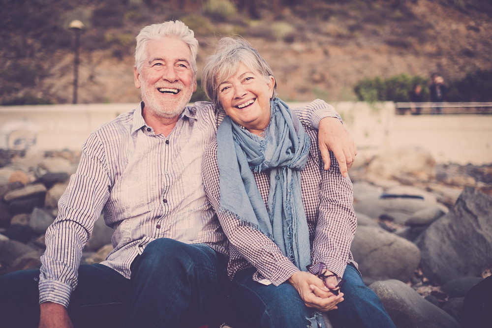 happy older couple sitting outside