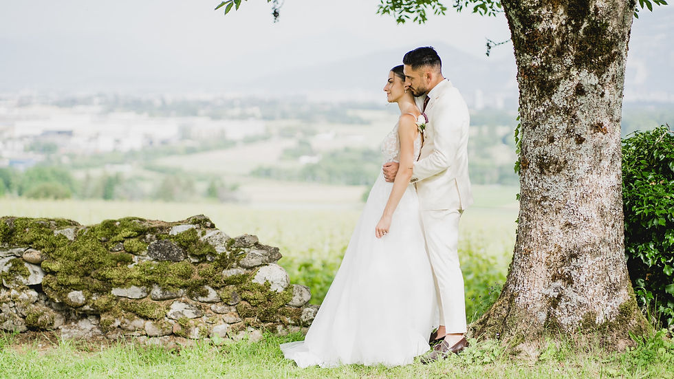 Couple de mariés enlacés dans un cadre naturel, la mariée dos au marié, scène romantique capturée en extérieur