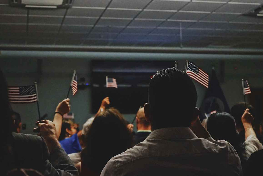 Photo of immigrants with United States Flags.