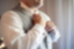 A young man straightens his tie.