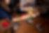 Two people clinking Carmela Coffee lattes in yellow cups over a table with cookies