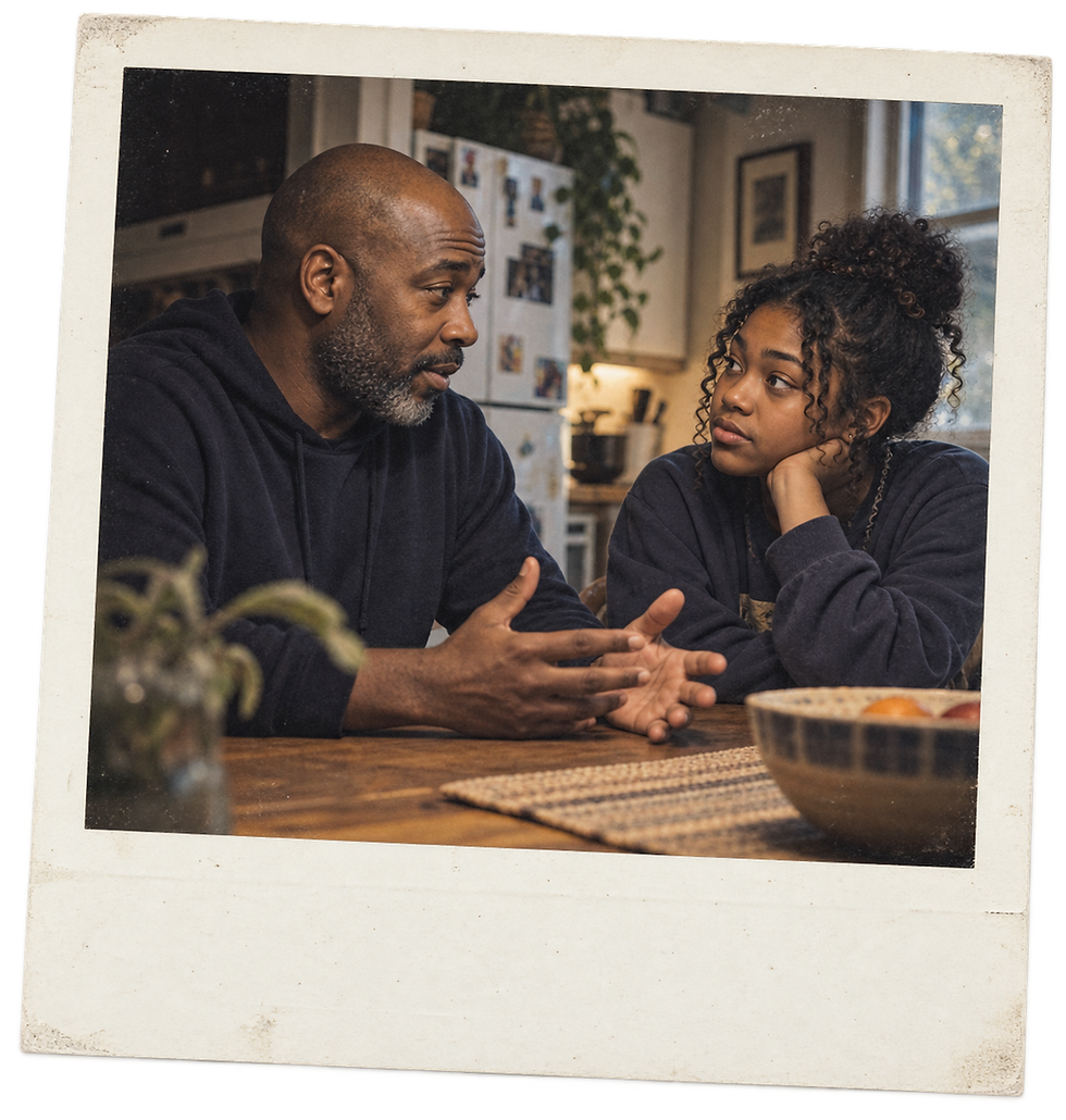 A Black father and teenage daughter talking openly at a kitchen table, caring candid intergenerational scene, no drinks.