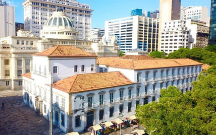 Grand bâtiment historique aux toits de tuiles, avec gratte-ciel