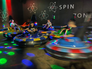 Guests spinning in neon-lit bumper cars at The Fun Lab’s Spin Zone in Blaine, MN.
