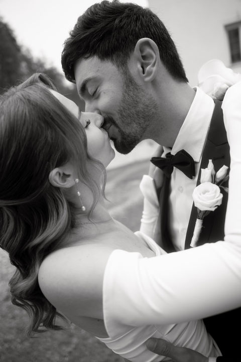 Bride and groom kissing during a civil wedding ceremony, photographed in black and white.
