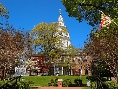 Maryland state house in Annapolis in springtime with Maryland flag in foreground