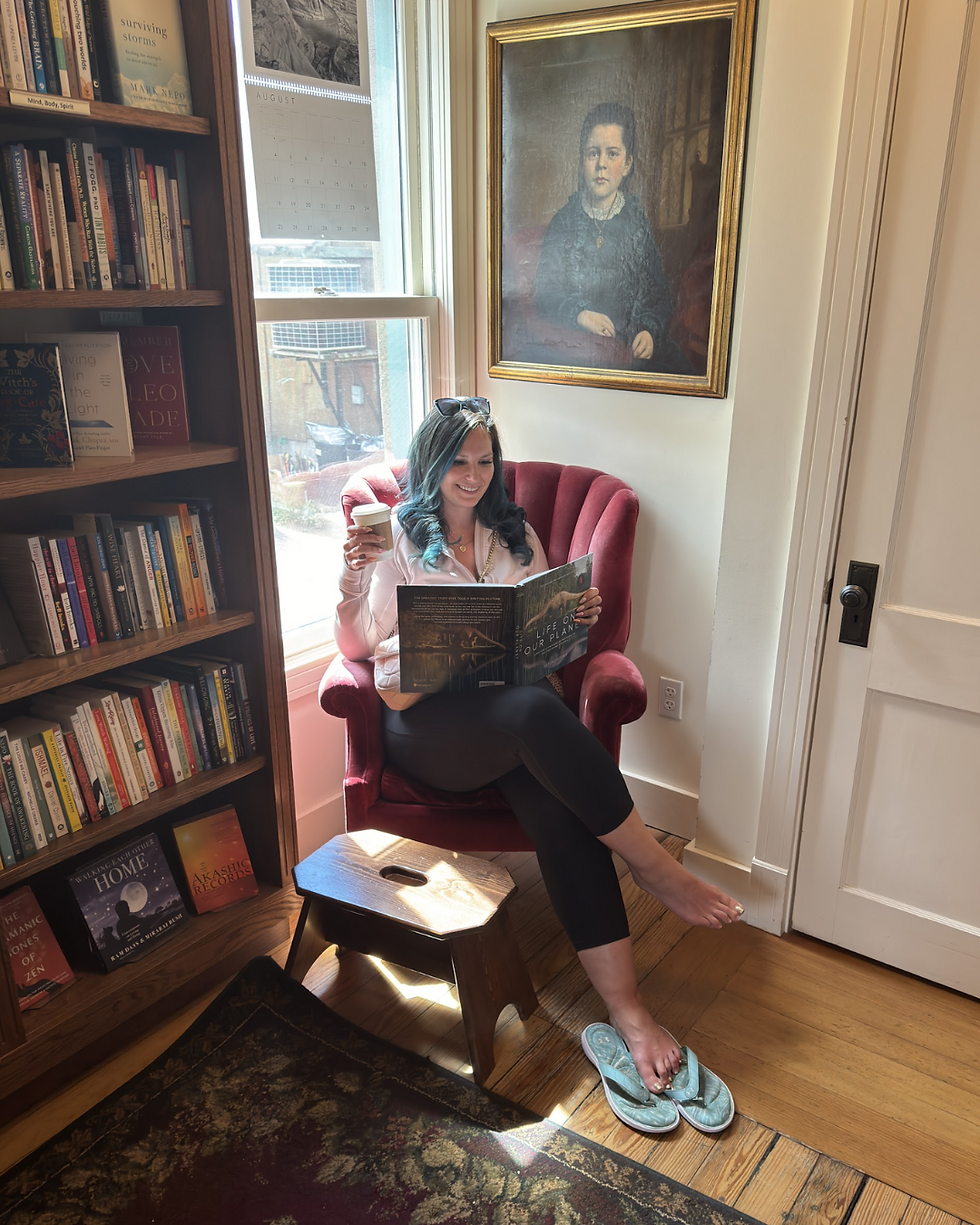 Rebecca Hamilton reading in a cozy bookshop corner, representing the power of storytelling and why writing your own book matters.