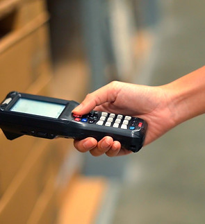 Close up hand scanning products with barcode scanner in warehouse..jpg