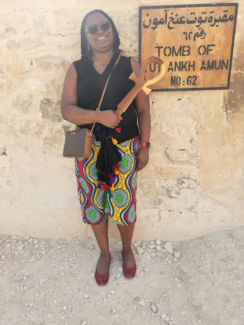 Tamara Baynham by a sign at the entrance of King Tut’s tomb at the Valley of the Kings, Egypt