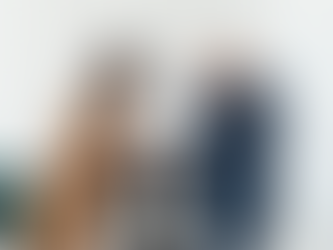 Office dispute with a woman arguing and a man holding his head, distressed. Another man sits at a desk in the background, looking stern.